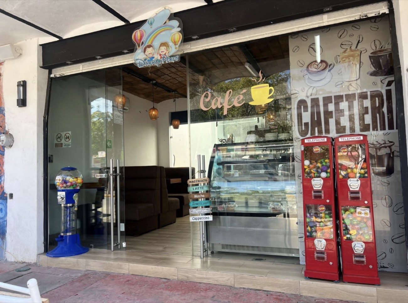 Entrada de la cafetería de Diverty Pekes con vitrina de postres y barra de café
